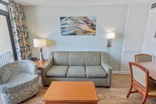 a living room with a couch and a table at New Remodeled Direct Oceanfront Views Beach Cove in Myrtle Beach