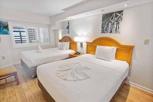 a hotel room with two beds with white sheets at New Remodeled Direct Oceanfront Views Beach Cove in Myrtle Beach
