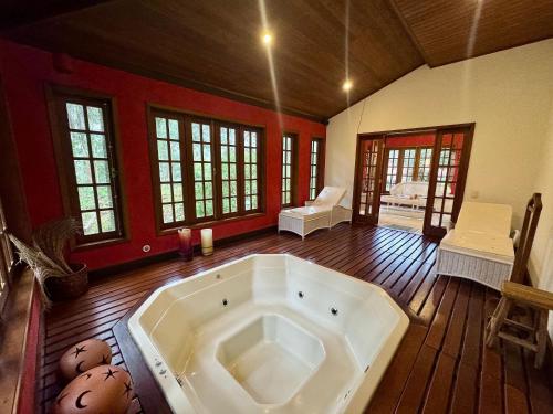 a large bath tub in a room with wooden floors at Fazenda Vale Dourado in Nova Friburgo