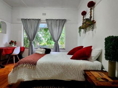 a bedroom with a bed with red pillows and a window at CLR-Accommodation in George