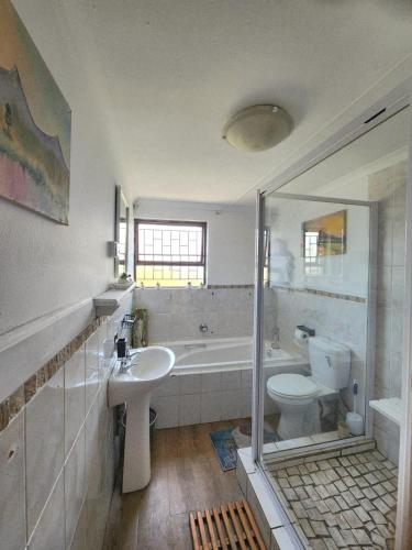 a bathroom with a sink and a toilet and a tub at CLR-Accommodation in George