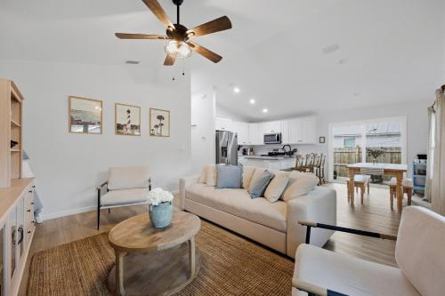 a living room with a white couch and a ceiling fan at Cozy Coastal Cottage Minutes to Beach and Downtown in St. Augustine