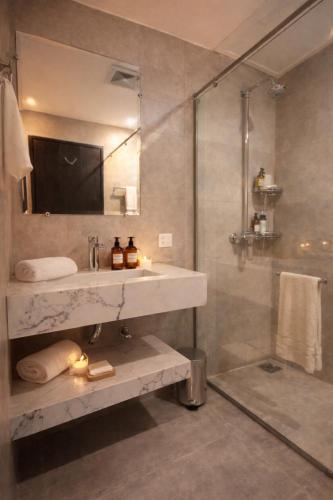 a bathroom with a sink and a shower at Daró - Self Check-in - 1 BR Apartment - Gulberg - MM Alam - Pool in Lahore