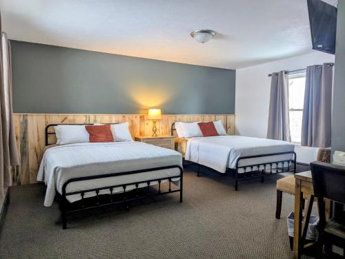 a hotel room with two beds and a window at Scotty's Motel in Munising