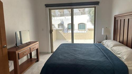 a bedroom with a bed and a tv and a window at Villa 1 en Hotel Tesoro Ixtapa in Ixtapa