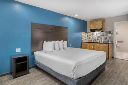 a bedroom with a large white bed and a blue wall at SureStay Hotel by Best Western Spring North Houston in Spring