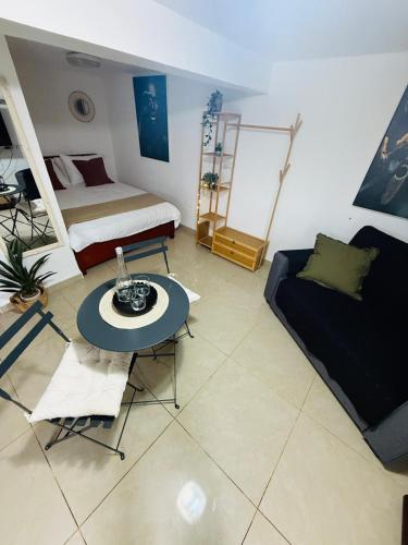 a room with a bed and a table and a couch at לרניקה - יחידות אירוח in Qiryat Shemona