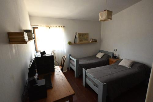 a small room with two beds and a table at Casa Amaranta in La Cumbre