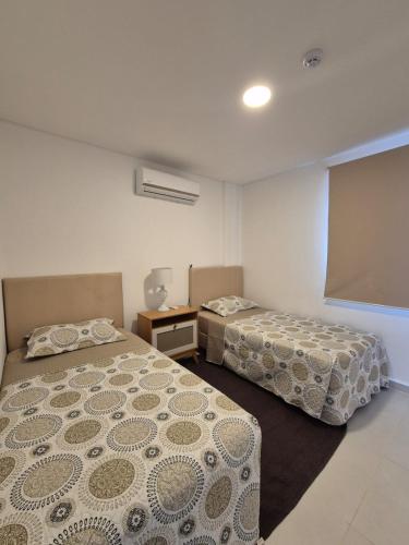 a room with two beds and a projection screen at LUXER VIVO Encarnacion in Encarnación