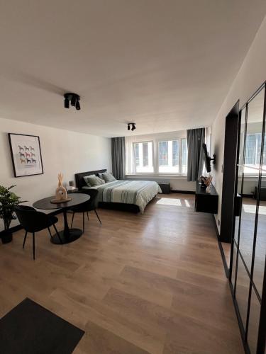 a living room with a bed and a table at Studio moderne et confort - Guillemins in Liège