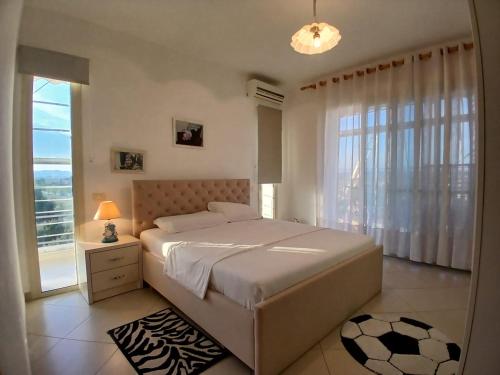 a bedroom with a large bed and a window at Sunrise Apartment Qerret in Kavajë