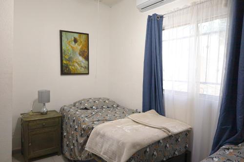 a bedroom with a bed and a dresser and a window at Entire accommodation in Bahia de la Paz in La Paz