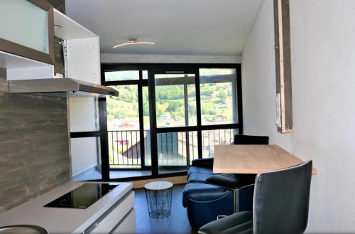 Studio, centre في لابريس: مطبخ به طاولة وكراسي في غرفة