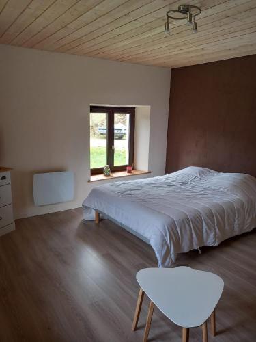 une chambre avec un lit, une table et une fenêtre dans l'établissement Studio Balneo, à La Bresse
