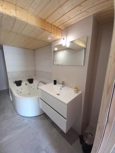 une salle de bain blanche avec un lavabo et une baignoire dans l'établissement Studio Balneo, à La Bresse