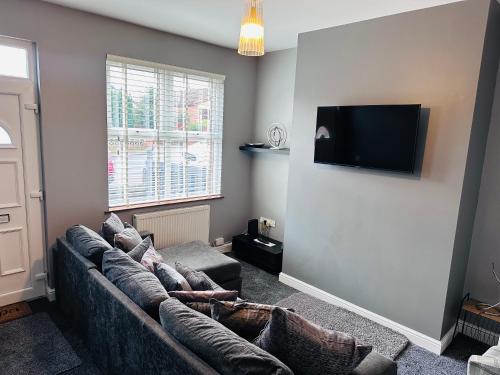 a living room with a couch and a flat screen tv at House in Hemingfield, Ideal for Contractors and Long Stays in Wombwell