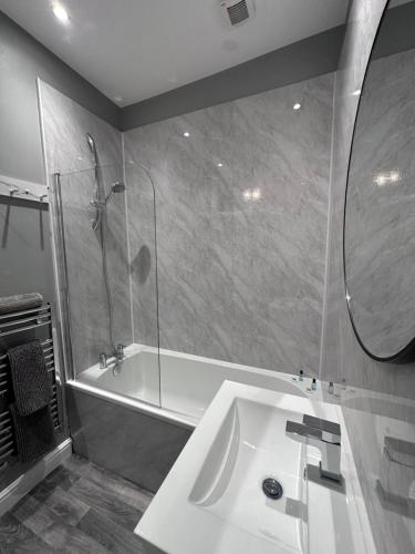 a bathroom with a tub and a sink and a shower at House in Hemingfield, Ideal for Contractors and Long Stays in Wombwell