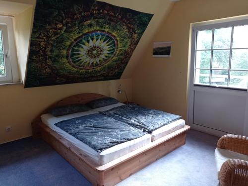a bedroom with a bed with a painting on the wall at Doppelzimmer mit Gartenblick in Reckershausen