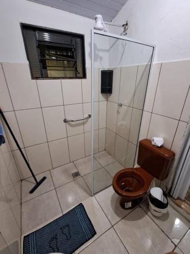 a bathroom with a toilet and a glass shower at Só pra Dormir centro in Brotas
