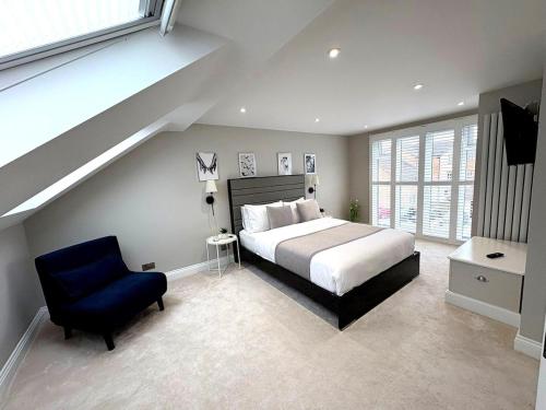 a bedroom with a large bed and a blue chair at Luxury home Cheshunt in Wormley