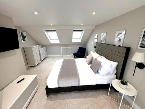 a bedroom with a large white bed and a chair at Luxury home Cheshunt in Wormley