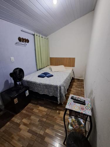 a small bedroom with a bed and a table at Só pra Dormir centro in Brotas