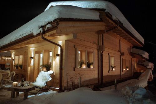 a log cabin with snow on top of it at Chalet-Hôtel Inarpa in La Clusaz