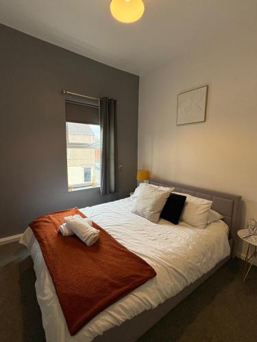 a bedroom with a large white bed with a window at Elegance apartments in West Cornforth