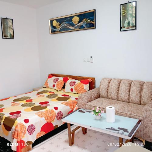 a living room with a bed and a couch at Les studios américains d'Angré - 2 in Mandanou