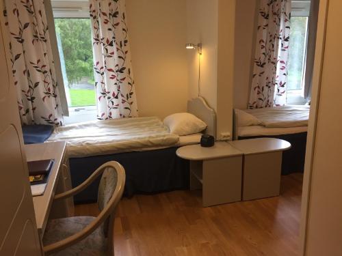 a small room with two beds and a table at Hindåsgården Hotel & Spa in Hindås