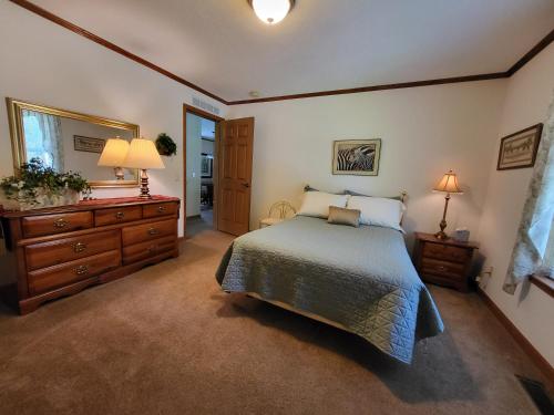 a bedroom with a bed and a dresser and a mirror at Pondview Escape a 75-Acre Retreat in Marion
