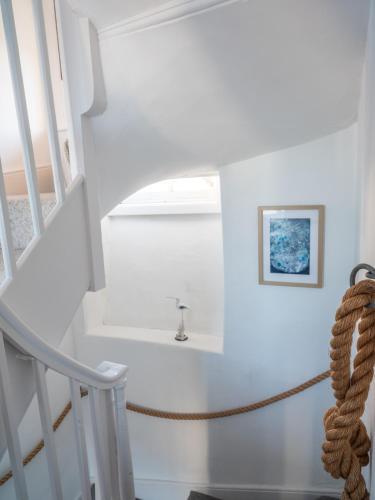a staircase with a rope in a house at Harbour View in Aberaeron