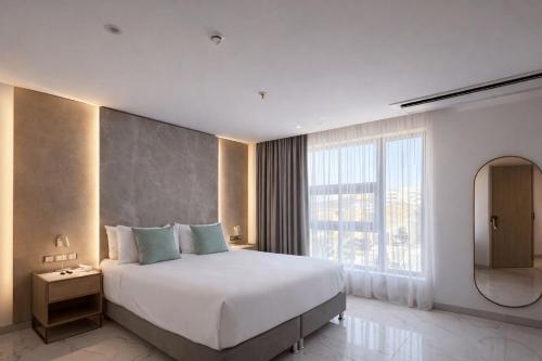 a bedroom with a large bed and a large window at Delamar Hotel in San Andrés