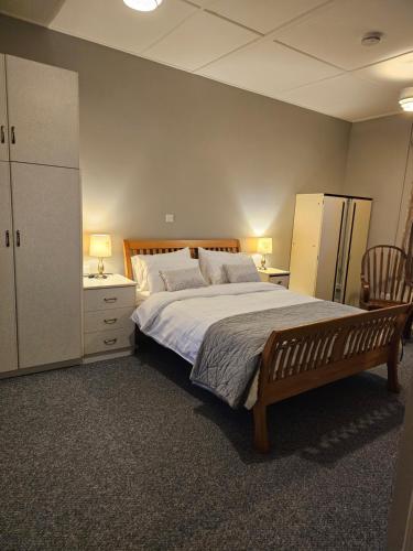 a bedroom with a large bed and a dresser and refrigerator at John's Farmhouse in Kilrush