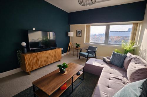 a living room with a couch and a tv at 2 Bed Flat - Contractor - Central MK - Parking - Sleeps5 in Milton Keynes