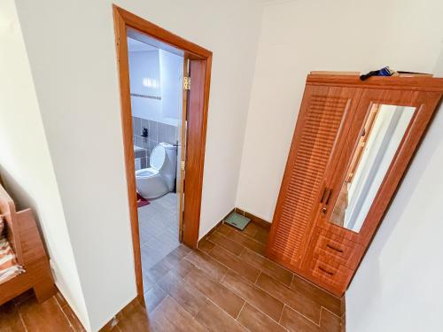 a bathroom with a toilet and a wooden door at Appart Congo-Warf- vue mer in Pointe-Noire