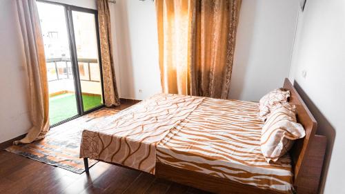 a bed in a room with a large window at Appart Congo-Warf- vue mer in Pointe-Noire