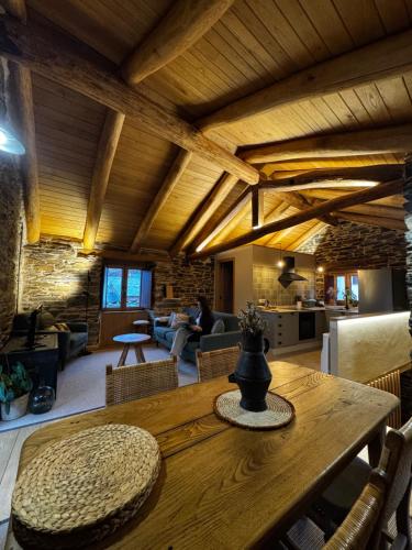 a living room with a wooden table and a living room at Lar da cima in Folgoso
