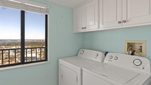 a laundry room with a washer and dryer and a window at Gull Watch by AvantStay in Panama City Beach