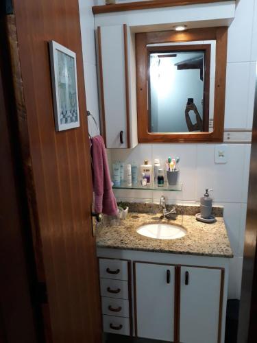 a bathroom with a sink and a mirror at Triplex com Piscina no Peró - Perto da Praia in Cabo Frio