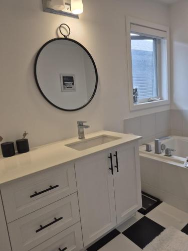 a bathroom with a sink and a mirror on the wall at The Creek Home in Kemptville