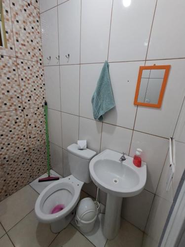 a bathroom with a toilet and a sink at Suite Nomar centro in Brotas
