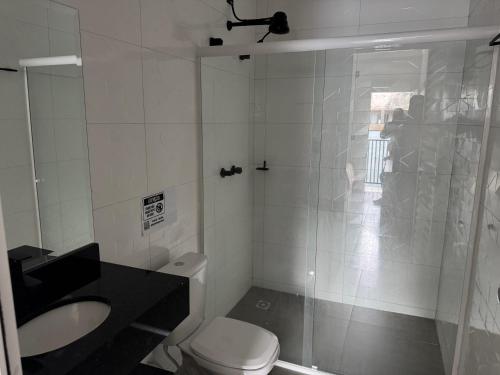 a bathroom with a shower and a toilet and a sink at Dallas hotel in Telêmaco Borba