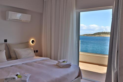 a bedroom with a bed with a view of the ocean at 9 Muses Apartments in Agios Nikolaos