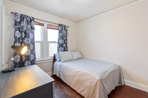 a small bedroom with a bed and a window at College Duplex in Grand Rapids