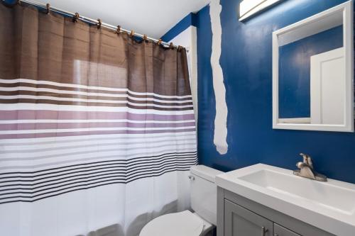 a bathroom with a toilet and a shower curtain at College Duplex in Grand Rapids