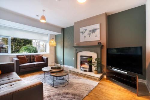 a living room with a couch and a fireplace at 10-min to City Centre 2 Bedrooms Sleeps4 with Free Parking Garden & WiFi in Aberdeen