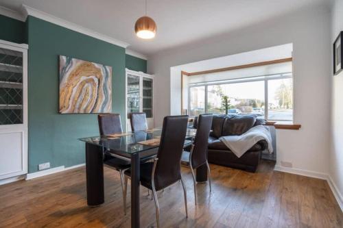 a dining room with a table and a couch at 10-min to City Centre 2 Bedrooms Sleeps4 with Free Parking Garden & WiFi in Aberdeen
