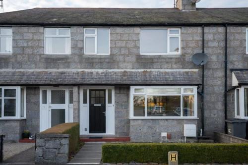 a brick house with white doors and windows at 10-min to City Centre 2 Bedrooms Sleeps4 with Free Parking Garden & WiFi in Aberdeen