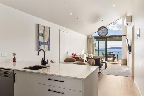 a kitchen and living room with a view of the ocean at Roam Taupo Upper Terrace Unit 4 - Spa Pool in Taupo